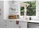 Bright kitchen with white cabinets, open shelving, stainless steel appliances and modern faucet at 5070 Hensley Dr, Atlanta, GA 30338