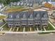 Aerial view of townhomes featuring manicured yards, street parking, and modern architectural design in a planned community at 579 Brashy St, Woodstock, GA 30188