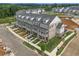 Aerial view showcasing newly constructed townhomes with well-manicured lawns and inviting front porches at 579 Brashy St, Woodstock, GA 30188