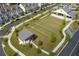Aerial view of a community gathering area including lawn seating, a concert stage, and a recreational barn at 579 Brashy St, Woodstock, GA 30188