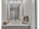 Clean bathroom featuring granite counters, a gray tiled shower, a decorative mirror, and modern fixtures at 579 Brashy St, Woodstock, GA 30188
