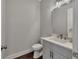 Modern half bathroom with a white vanity and dark wood flooring at 579 Brashy St, Woodstock, GA 30188