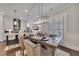 The dining area is located adjacent to a kitchen and features a wooden table, upholstered chairs, and stylish lighting at 579 Brashy St, Woodstock, GA 30188