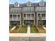 Three townhomes with brick facades, private yards, picket fences, and inviting porches and balconies at 579 Brashy St, Woodstock, GA 30188