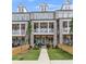 Charming townhouse featuring a brick facade, second-story balconies, manicured landscaping, and inviting entryways at 579 Brashy St, Woodstock, GA 30188
