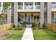 Townhome with a cozy porch, a yellow door adorned with wreaths, and manicured front yard landscaping at 579 Brashy St, Woodstock, GA 30188