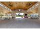 Spacious barn interior with high ceilings, ceiling fans, picnic tables, and colorful chairs for social gatherings at 579 Brashy St, Woodstock, GA 30188