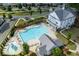 Aerial view of a community pool with lounge chairs, splash pad, and landscaped gardens surrounded by residential homes at 579 Brashy St, Woodstock, GA 30188