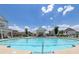 Large community swimming pool with lounge chairs, umbrellas, and nearby buildings at 579 Brashy St, Woodstock, GA 30188