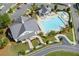 Aerial view of a stunning community pool area with a clubhouse, lounge chairs, landscaping, and parking at 579 Brashy St, Woodstock, GA 30188
