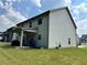 A home's backyard, featuring siding, a covered patio, and a well-maintained lawn at 7487 Rudder Cir, Fairburn, GA 30213