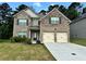 Charming brick two-story home with a manicured lawn and a two-car garage at 7487 Rudder Cir, Fairburn, GA 30213