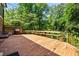 Spacious wood deck with a built-in bench and a grill surrounded by greenery at 285 Jade Cove Dr, Roswell, GA 30075