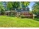 Spacious backyard with a well-manicured lawn, brick accents, and a large deck, perfect for outdoor enjoyment at 285 Jade Cove Dr, Roswell, GA 30075