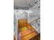 Stairwell with newspaper print wallpaper and multicolored carpet on the steps at 285 Jade Cove Dr, Roswell, GA 30075