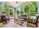 Bright sunroom with ample seating and views of the green, lush backyard at 285 Jade Cove Dr, Roswell, GA 30075