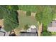 Aerial view of a home's backyard with a patio, fire pit, and lush, mature trees at 4345 Idlewood Dr, Cumming, GA 30040