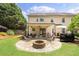 Spacious backyard with a covered patio, stone fire pit, and outdoor seating perfect for entertaining at 4345 Idlewood Dr, Cumming, GA 30040