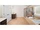 Well-lit bathroom featuring a soaking tub, separate shower, and double doors for added privacy at 4345 Idlewood Dr, Cumming, GA 30040