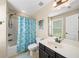 Bathroom with a single sink vanity, a shower and bathtub combination, and a blue shower curtain at 4345 Idlewood Dr, Cumming, GA 30040