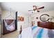 Bright bedroom with unique hanging chair, wooden dresser, and a bed with a striped comforter at 4345 Idlewood Dr, Cumming, GA 30040