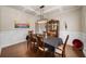 Elegant dining room featuring wainscoting, hardwood floors, coffered ceiling, and modern lighting at 4345 Idlewood Dr, Cumming, GA 30040