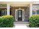 Welcoming entryway with a black front door, flanked by sidelights, brick facade and trimmed shrubbery at 4345 Idlewood Dr, Cumming, GA 30040