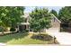 Attractive home with a brick and siding exterior, complemented by a lush green lawn and mature trees at 4345 Idlewood Dr, Cumming, GA 30040