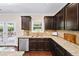 Detailed view of kitchen area with granite countertops, dark cabinets, and stainless steel dishwasher at 4345 Idlewood Dr, Cumming, GA 30040