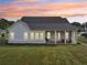 A beautifully landscaped backyard featuring a covered patio, lush green lawn, and inviting outdoor space at 4720 Down Setting Rd, Cumming, GA 30028