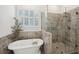 Modern bathroom featuring a soaking tub, a glass-enclosed shower with stone tile, and plantation shutters at 4720 Down Setting Rd, Cumming, GA 30028