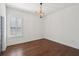 Bright, empty bedroom with beautiful floors, decorative light fixture, and a large window at 4720 Down Setting Rd, Cumming, GA 30028