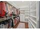 Spacious walk-in closet with custom built in shelves and wood floors at 4720 Down Setting Rd, Cumming, GA 30028