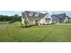 Charming modern farmhouse on a lush green lawn with mature landscaping and dark metal perimeter fence at 4720 Down Setting Rd, Cumming, GA 30028