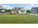 Charming modern farmhouse featuring a well-manicured lawn, black roof and a pair of rocking chairs at 4720 Down Setting Rd, Cumming, GA 30028