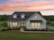 Beautiful modern farmhouse during sunset featuring a well-manicured lawn and lovely curb appeal at 4720 Down Setting Rd, Cumming, GA 30028