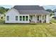 Charming white home showcasing a covered patio and manicured lawn, perfect for outdoor living and relaxation at 4720 Down Setting Rd, Cumming, GA 30028