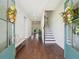Welcoming foyer featuring hardwood floors, fresh paint, beautiful door wreaths, and an open staircase to the upper level at 4720 Down Setting Rd, Cumming, GA 30028