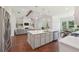 Modern kitchen with view into the living area with fireplace, large island, and stainless appliances at 4720 Down Setting Rd, Cumming, GA 30028
