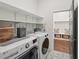 Laundry room with modern washer and dryer and shelving with storage bins and baskets at 4720 Down Setting Rd, Cumming, GA 30028