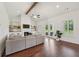 Bright living room with a cozy fireplace, built-in shelves, beamed ceiling, hardwood floors, and French doors to backyard at 4720 Down Setting Rd, Cumming, GA 30028