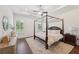 Spacious main bedroom with a four-poster bed, hardwood floors, and neutral decor offers a relaxing retreat at 4720 Down Setting Rd, Cumming, GA 30028