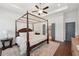 Comfortable main bedroom showcases a four-poster bed, ceiling fan and adjoins a spacious private bathroom at 4720 Down Setting Rd, Cumming, GA 30028