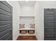 Mudroom featuring a built-in bench with storage baskets and decorative pillows, with two entries at 4720 Down Setting Rd, Cumming, GA 30028
