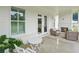 Covered patio with a brick fireplace, seating, and white table set, perfect for outdoor relaxation at 4720 Down Setting Rd, Cumming, GA 30028