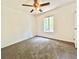 Cozy bedroom with a ceiling fan, window view, and wall to wall carpet at 5968 Hilltop Dr, Douglasville, GA 30135