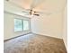 Spacious bedroom featuring a ceiling fan, large window, and neutral carpet at 5968 Hilltop Dr, Douglasville, GA 30135
