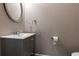Neutral half bathroom featuring a gray vanity, round mirror, and modern fixtures at 1360 Mount Mickinley Dr, Grayson, GA 30017