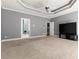 Large main bedroom featuring a tray ceiling, ceiling fan, and multiple doorways at 1360 Mount Mickinley Dr, Grayson, GA 30017