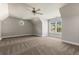 Upstairs bedroom with plush carpet, ceiling fan, and windows offering a view of neighborhood at 1360 Mount Mickinley Dr, Grayson, GA 30017